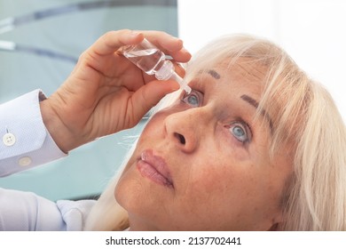 Senior Woman Drips Eye Drops Into Her Eyes. Woman Suffering From Irritated Eyes Or Eye Diseases. Vision And Ophthalmology Medicine.