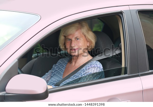 Senior woman driving a\
car.