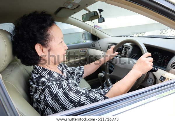 Senior woman driving\
car