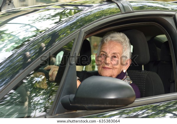 senior woman driving a\
car