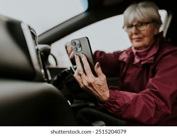 Senior woman driving, using GPS on smartphone - Powered by Shutterstock