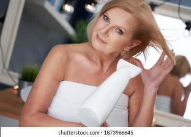 Senior Woman Drying Hair In The Bathroom