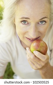 Senior Woman Eating Apple Outdoors