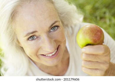 Senior Woman Eating Apple Outdoors