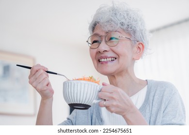 Senior woman eating breakfast with a smile - Powered by Shutterstock