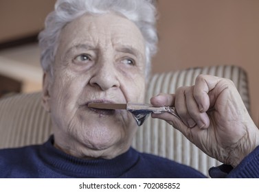 Senior Woman Eating Chocolate Bar