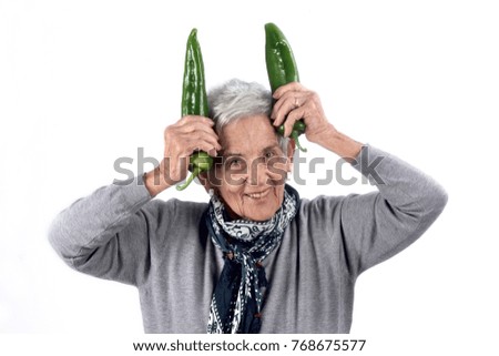 senior woman eating pepper on white