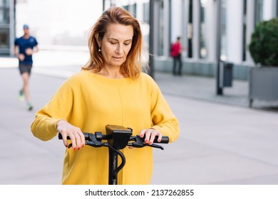 Senior Woman With Electric Scooter In The City