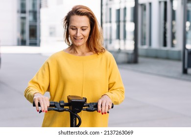 Senior Woman With Electric Scooter In The City