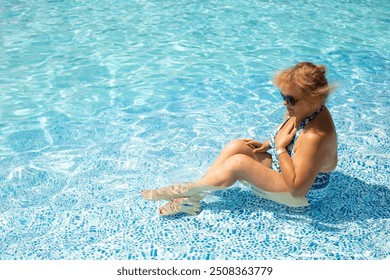 Senior Woman Enjoying Summer Vacation in bikini swimsuit near blue water pool. Healthy lifestyle in retirement - Powered by Shutterstock