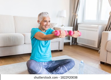 Senior Woman Exercise With Dumbbells At Home . Happy Mature Woman Doing Arm Workout Using Dumbbells. Elderly Woman Prefers Healthy Lifestyle