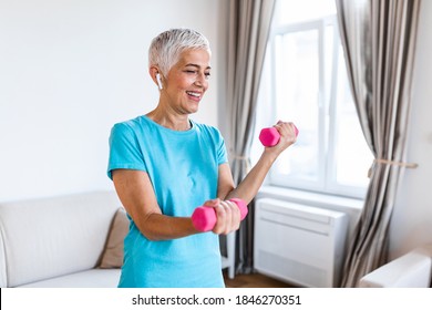 Senior Woman Exercise With Dumbbells At Home . Happy Mature Woman Doing Arm Workout Using Dumbbells. Elderly Woman Prefers Healthy Lifestyle