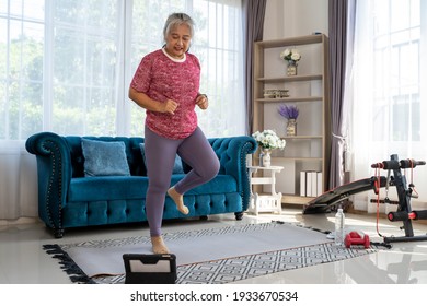 Senior woman exercise with jog in place, she watch laptop for Training exercise online In Living Room During Quarantine