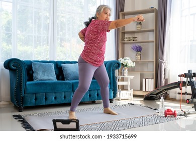 Senior woman exercise with standing and boxing jabs to side, she watch laptop for Training exercise online In Living Room During Quarantine