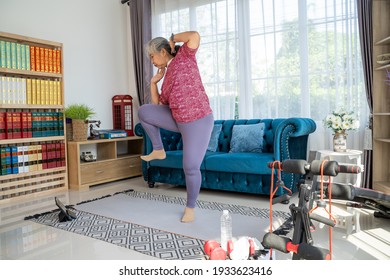 Senior woman exercise with standing oblique crunch or side crunch, she watch training online in tablet during workout