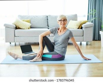 Senior Woman Exercise Using Laptop Online Instructions At Home Health Care 