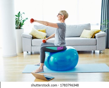 Senior Woman Exercise Using Laptop Online Instructions At Home Health Care 