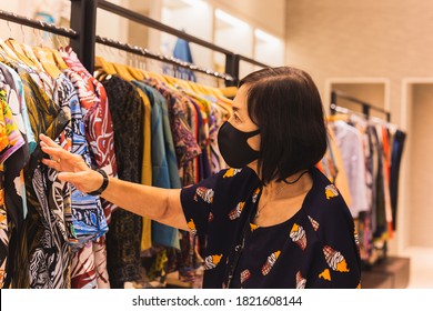 Senior Woman With Face Mask Is Shopping Clothes In The Department Store New Normal.