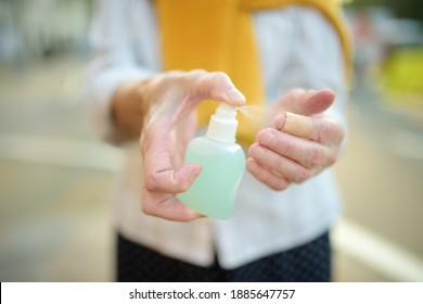 Senior Woman In Face Mask Using Sanitizer Because The Second Wave Of The Covid-19 Epidemic Began. Lockdown.Mask And Disinfection Of Hands Is New Normal For Protection And Prevention During Coronavirus