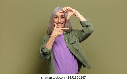 senior woman feeling happy, friendly and positive, smiling and making a portrait or photo frame with hands - Powered by Shutterstock