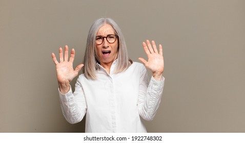 Senior Woman Feeling Stupefied And Scared, Fearing Something Frightening, With Hands Open Up Front Saying Stay Away