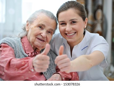Senior woman and female nurse are showing thumbs up