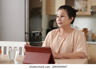 Senior Woman Filling Insurance Claim Form On Tablet Computer Online