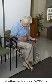 Senior Woman Filling Out Forms At The Doctor`s Office