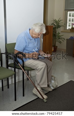 Senior woman filling out forms at the doctor`s office