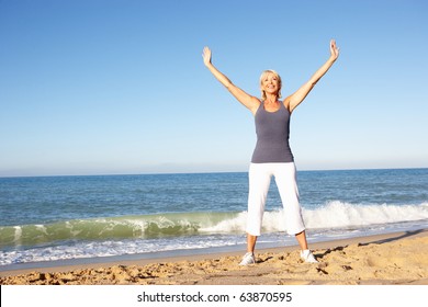 Senior Woman In Fitness Clothing Stretching On Beach - Powered by Shutterstock