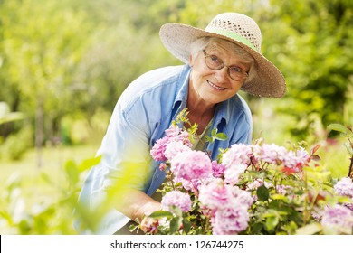 Senior Woman With Flowers In Garden