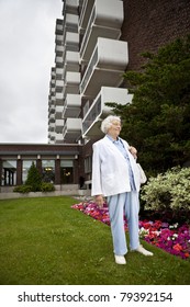 Senior Woman In Front Of Apartment Building