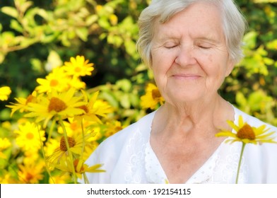 Senior Woman In Garden Full Of Flowers. MANY OTHER PHOTOS FROM THIS SERIES IN MY PORTFOLIO.