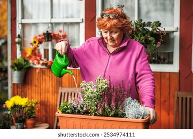 Senior woman gardening in her backyard, planting flowers in a pot and watering them with care. Happy pensioner enjoying outdoor activities - Powered by Shutterstock