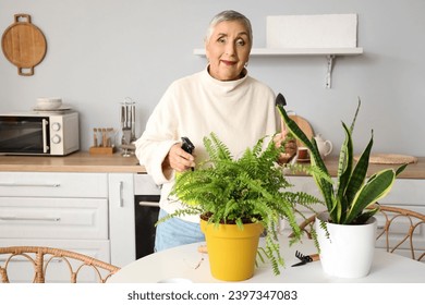 Senior woman with gardening tools and plants in kitchen - Powered by Shutterstock