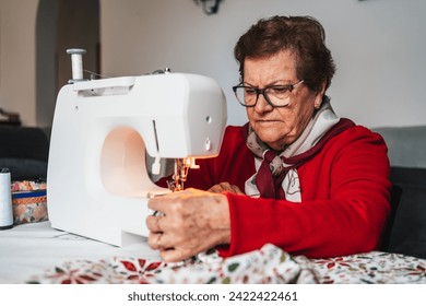 senior woman with glasses making a dress on sewing machine - Powered by Shutterstock