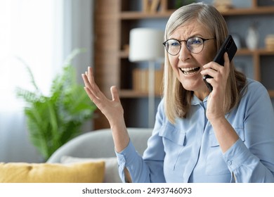 Senior woman with glasses talking on phone indoors looking upset or frustrated. Elderly lady having difficult conversation expressing emotions. - Powered by Shutterstock