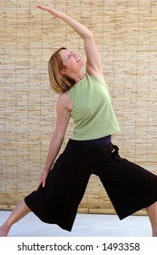 Senior Woman Going Into The Reverse Warrior Yoga Pose.