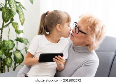 Senior Woman With Grandkid Playing Game On Smartphone