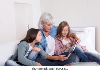 Senior Woman With Grandkids Playing With Touchpad