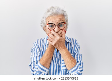 Senior Woman With Grey Hair Standing Over White Background Shocked Covering Mouth With Hands For Mistake. Secret Concept. 