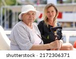 Senior woman with guardian on walk in summer. Help and support for pensioners concept