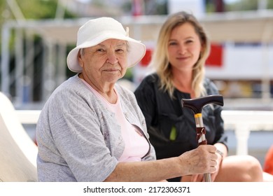 Senior woman with guardian on walk in summer. Help and support for pensioners concept
