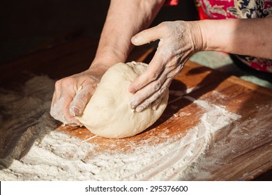 Senior woman hands knead dough on a table in her home kitchen - Powered by Shutterstock