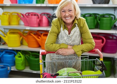 Senior Woman As A Happy Customer With Shopping Cart In The Garden Center Or Hardware Store