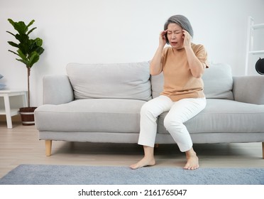 senior woman have a headache on a sofa - Powered by Shutterstock