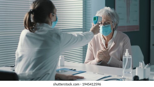 Senior Woman Having A Body Temperature Check In The Doctor's Office, Coronavirus Prevention Concept