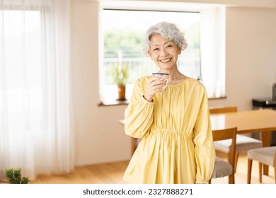 A senior woman is having a drink. - Powered by Shutterstock