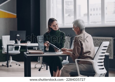 Senior woman having a meeting with financial advisor while sitting in the office together