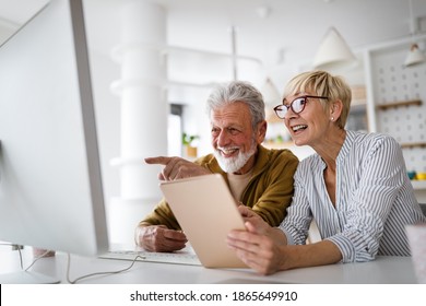 Senior Woman Helping Senior Man To Use Computer